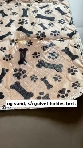 Hvalp ved en pyt på gulvet, tissemåtten med poter og knogler, og måtten der kommer i vaskemaskinen